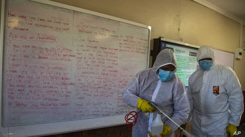Disinfection team disinfect a classroom at Ivory Park Secondary School east of Johannesburg, South Africa, Thursday, May 28, 2020, ahead of the June 1, 2020, re-opening of Grade 7 and 12 learners to school. Photo credit (AP Photo/Themba Hadebe)