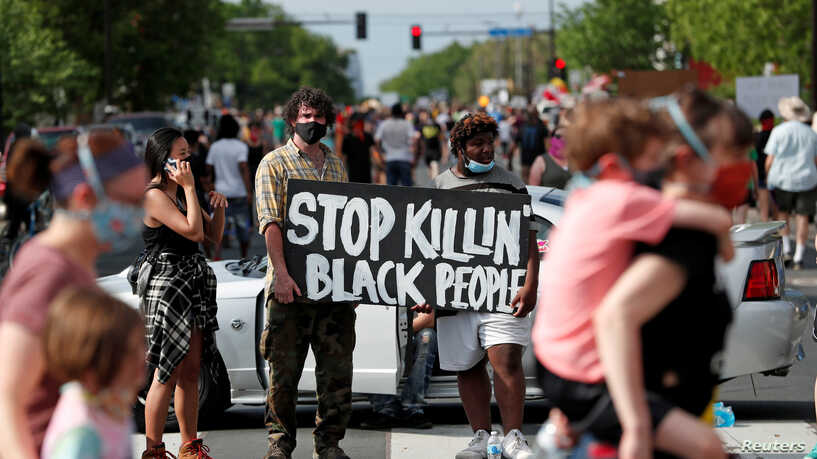 Protesters gather at the scene where George Floyd, an unarmed black man, was pinned down by a police officer kneeling on his neck before later dying in hospital in Minneapolis, Minnesota, U.S. May 26, 2020. REUTERS/Eric Miller