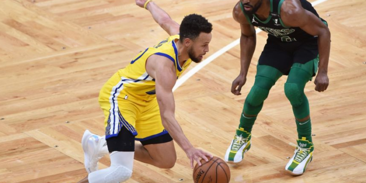 REUTERS | Stephen Curry controls the ball while Kemba Walker defends in Boston, on April 17, 2021