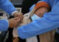 AFP | A Libyan medic administers the AstraZeneca vaccine to an elderly woman in Tripoli as authorities launch a national inoculation drive against coronavirus