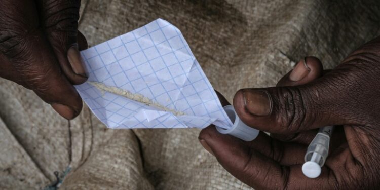Addiction: A heroin user in Nairobi's Kawangware slum prepares a fix | AFP