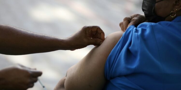 A health worker gets her first dose of Covid vaccine in Abuja, Nigeria | AFP