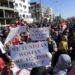 Tunisian demonstrators raise placards as they protest in front of the parliament, against President Kais Saied's seizure of governing powers, in the capital Tunis, on November 14, 2021 | AFP