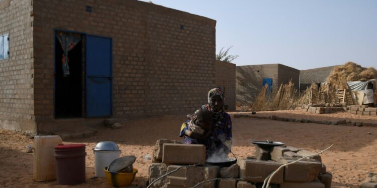 A Malian refugee cooks outside her home in Ouallam | AFP