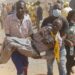A CCC supporter is carried away from the violence after breaking a leg in a stampede | AFP