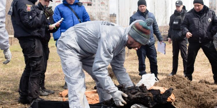 A forensic worker exhumes several bodies from a grave in Bucha, Ukraine, on April 12, 2022 | Anastasia Vlasova/Getty Images