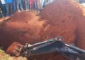 An excavator   digs through  a pit latrine where a man was trapped after it caved in.Photo/Courtesy