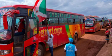 The Burundian flag flies at the head of a convoy of buses moving refugees back home from Tanzania in 2019 | Tchandrou Nitanga/AFP via Getty Images